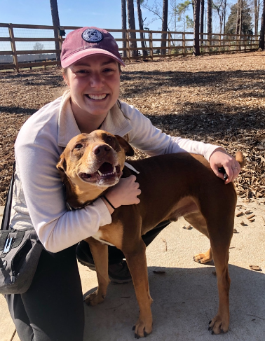 Victoria smiling with a happy dog